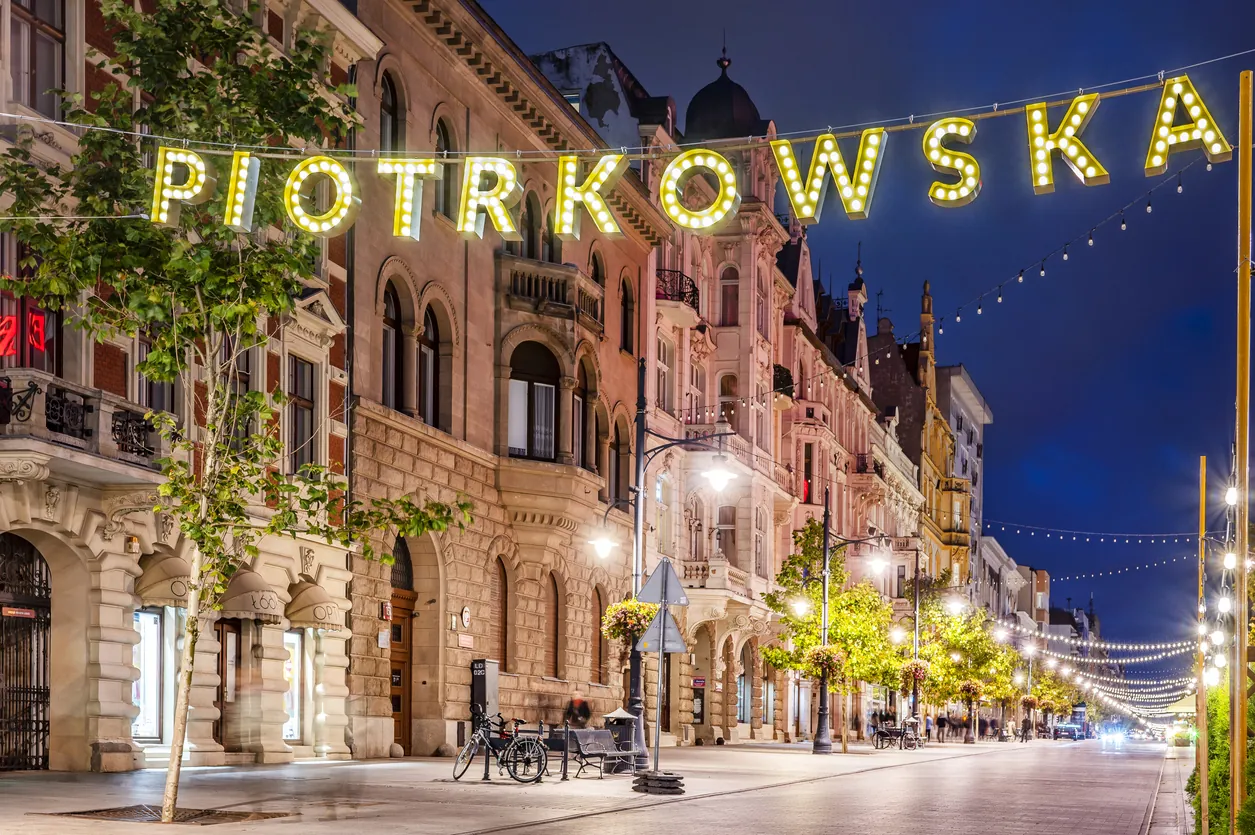 Ulica Piotrkowska w Łodzi wieczorem, neon z nazwą ulicy nad kamienicami